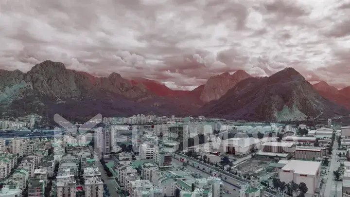 Magic landscape of the city against the backdrop of mountains. Cloudy sky. Flight over rooftops. Aerial drone view