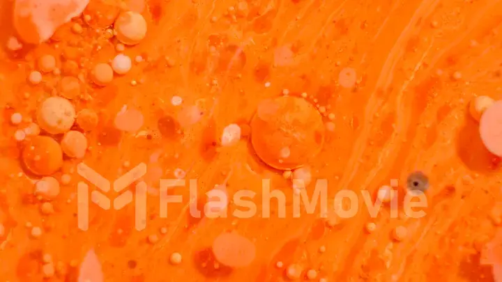 Bright colorful orange bubbles on the surface of the water. Abstract paint bubbles