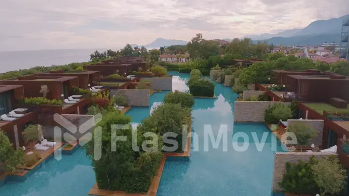 Aerial drone view of the hotel courtyard. Vacation at the resort. Green shrubs. Mountains in the background