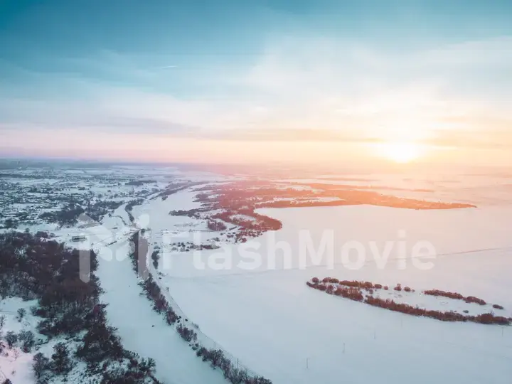 The Aerial view of snow-covered forest in time of sunny winter evening.