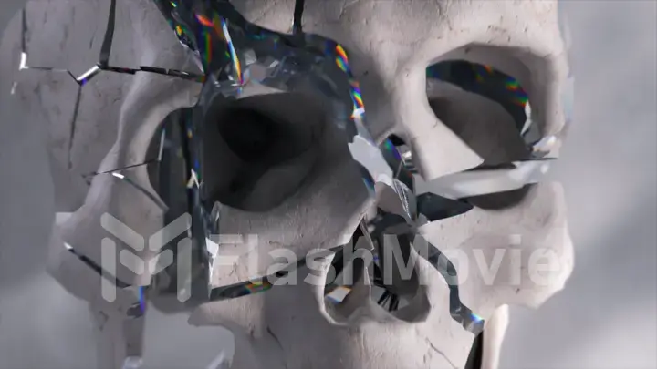 Horror concept. The white plaster skull shatters into many diamond shards. Shards of glass. Close-up. Rainbow