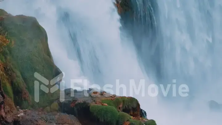 Aerial drone view of a natural waterfall close-up. Spray. Foam. Green vegetation on the rocks. Wildlife concept.