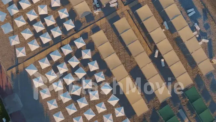 Top view of beach chairs, sand, beach umbrellas, coastline. Vacation.