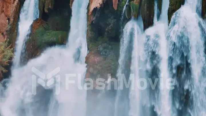 White foamy waterfall flows from the cliff. Close-up drone view. The power of the elements. Reserve.