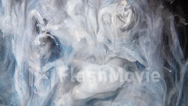 Abstract bronze paint mixed with different multi-colored paints in water in slow motion. Inky cloud swirling flowing underwater. Abstract smoke explosion