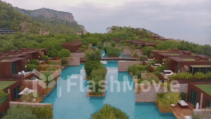 Aerial drone view of the hotel courtyard. Vacation at the resort. Green shrubs. Mountains in the background