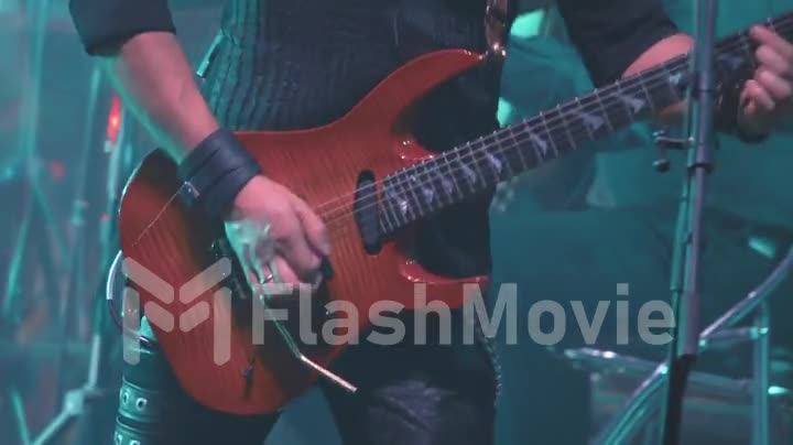 A virtuoso guitarist playing an electric guitar on stage with flashing LED lights.