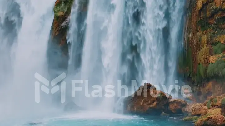 Aerial drone view of a natural waterfall close-up. Spray. Foam. Green vegetation on the rocks. Natural element.