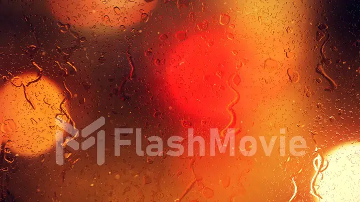 Raindrops on a car window with beautifully blurred background of street traffic lights