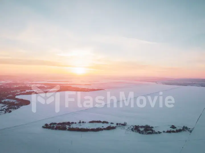 The Aerial view of snow-covered forest in time of sunny winter evening.