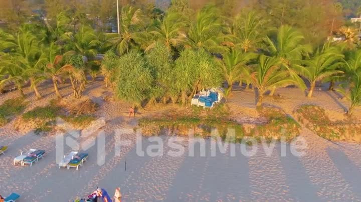 PHUKET, THAILAND - 15 MAR 2020: Sunset on Karon beach, people swim in the sea and sunbathe, resort beach. A few days before closing beaches due to quarantine covid-19. Aerial 4k footage