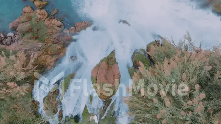 Rapid waterfall on the red rock. Azure water. Plants on the rocks. Aerial drone view