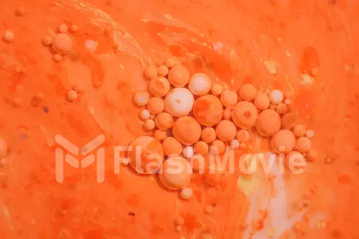 Bright colorful orange bubbles on the surface of the water. Abstract paint bubbles