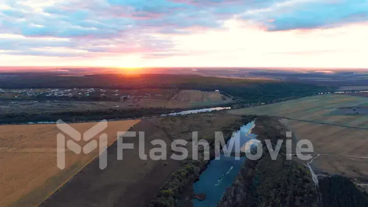 Flight in the beautiful countryside among a river of woods and fields near the city