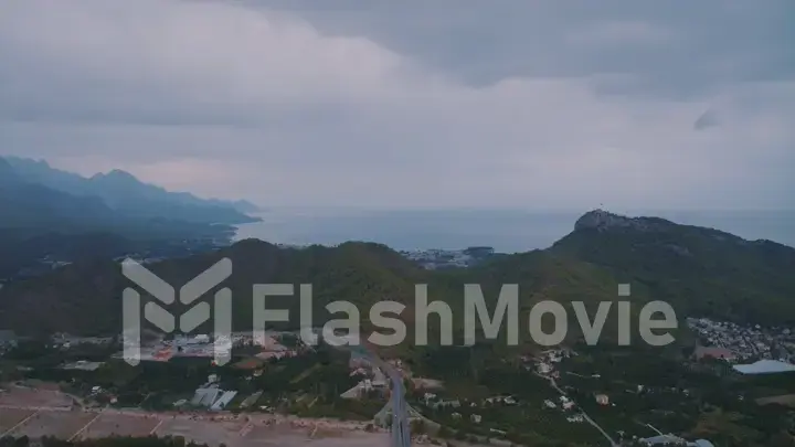 Landscape at sunset. Aerial drone view of the resort town. Clouds. Mountains in the background