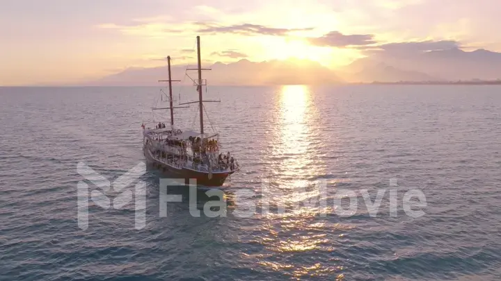 Vintage sailing ship sails on the sea at sunset. Seascape. Calm water. Top view. Aerial drone view.