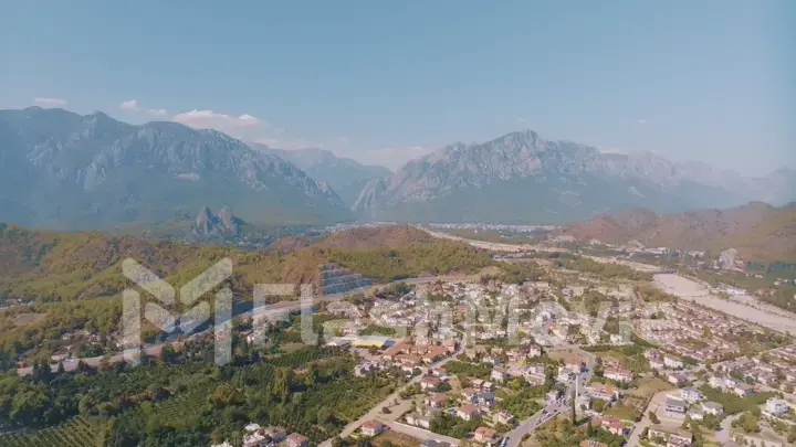 Aerial panorama of small resort town. Hotels, houses and roads. Green hills around. Mountain landscape. Photography