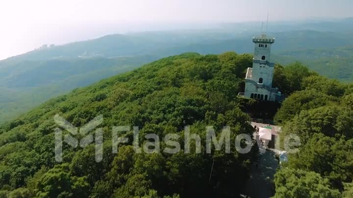 Aerial 4k view. Beautiful castle on the mountain on a summer sunny day, view of the mountains and the sea