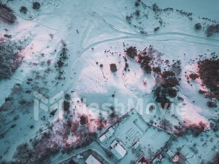 The Aerial view of snow-covered forest in time of sunny winter evening.