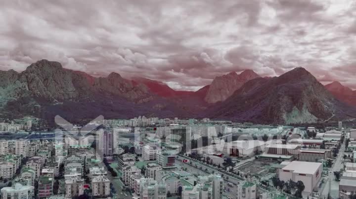 Magic landscape of the city against the backdrop of mountains. Cloudy sky. Flight over rooftops. Drone video footage
