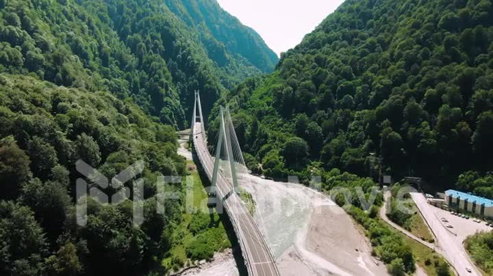 Aerial 4k view. Suspension bridge over the river. Flying over the bridge among mountains and rocks.