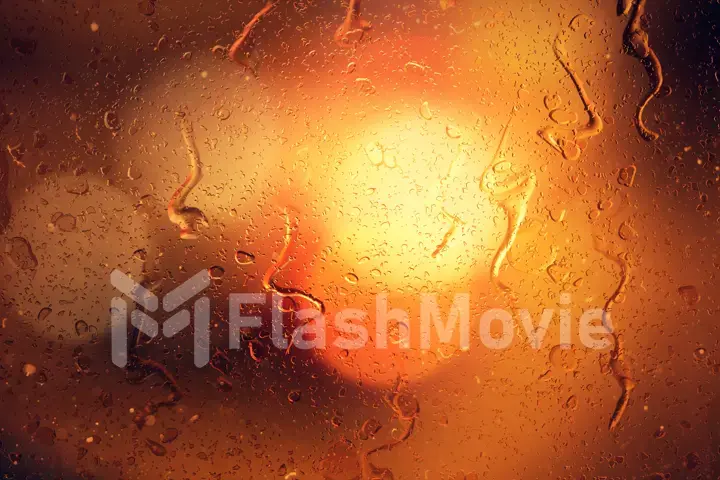 Raindrops on a car window with beautifully blurred background of street traffic lights