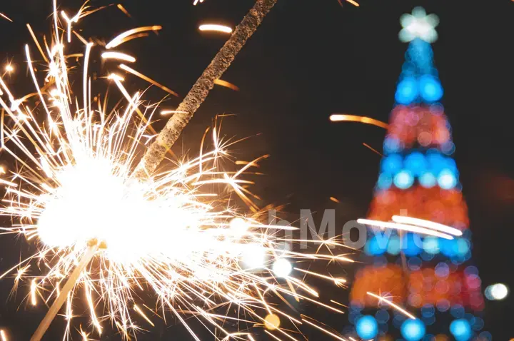 Bengal fire in hand, sparkling and colorful Christmas bokeh, new year.