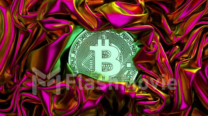 A fabric of metallic neon pink is wrinkled around the bitcoin. Shiny fabric. Cryptocurrency. Creases in fabric. Drapery