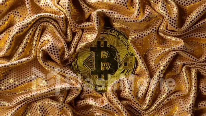 Cryptocurrency concept. A golden bitcoin surrounded by a shiny gold textile. Creases in fabric. 3d animation