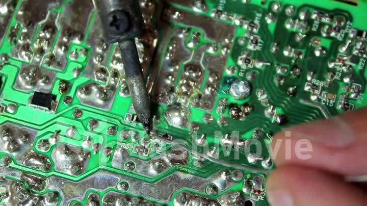 Close up shot soldering a circuit board with a soldering iron
