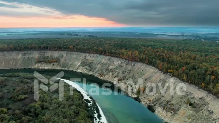 Colorful nature at dusk, the river bends along the mountains and forests, colorful sunset, 4k aerial view