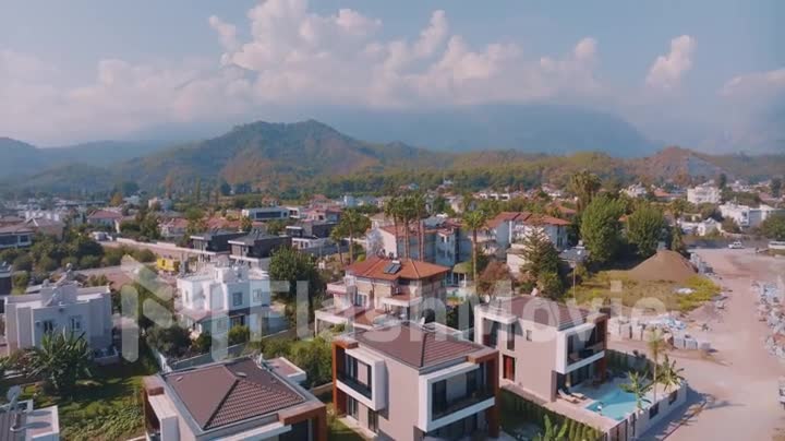 Aerial drone video footage. Panoramic view of the resort town against the backdrop of mountains. Top view.