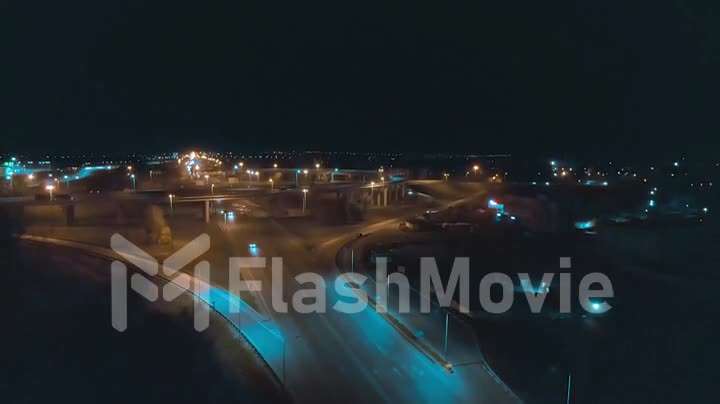 Aerial 4k view urban night traffic on the illuminated roundabout
