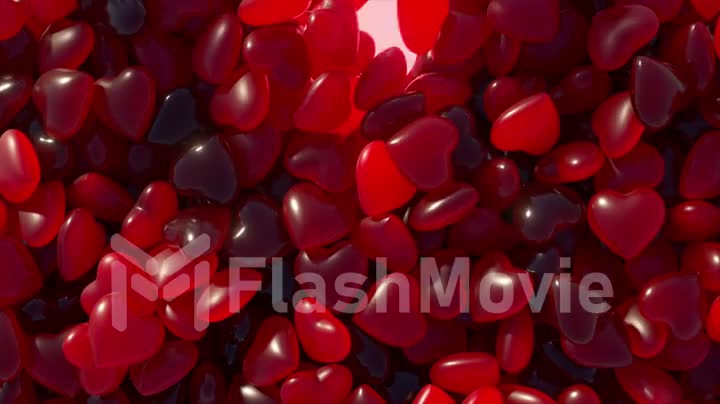 Valentine's Day. A red neon heart jumps out of a pile of dark blue hearts. Heart shaped gummies. Sweets. 3d animation