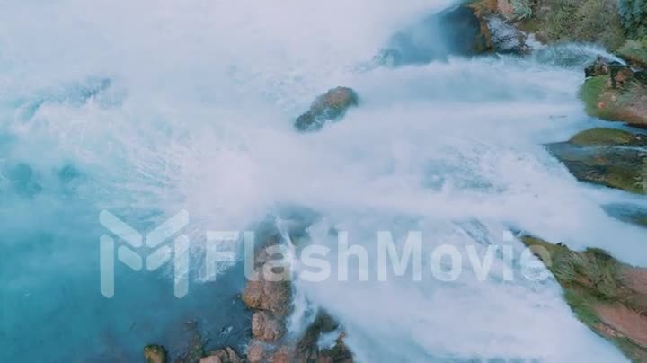 Stormy waterfall on a rock. Fast mountain water. Harmony with nature. Drone slow motion footage.