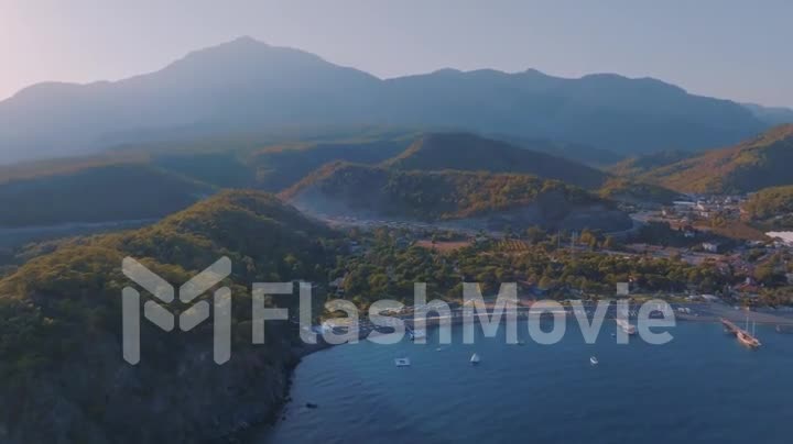 Bay at sunset. Dense forest on the coast. Water transport floats. Light fog. Aerial drone video footage