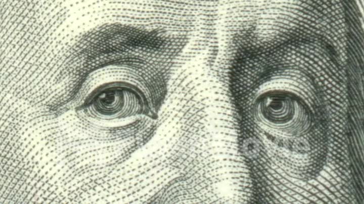 Close up Benjamin Franklin's face on the US one hundred dollar bill US dollars background.