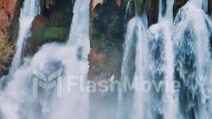 White foamy waterfall flows from the cliff. Close-up drone footage. The power of the elements. Reserve.