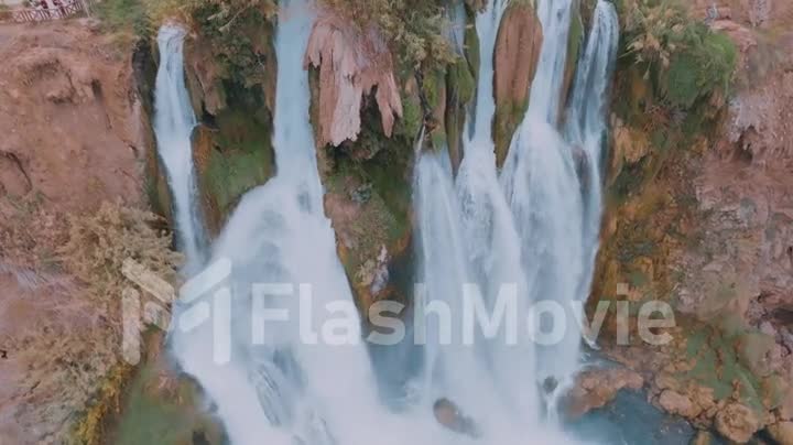 Natural stormy waterfall. Harmony with nature. Aerial drone video footage.
