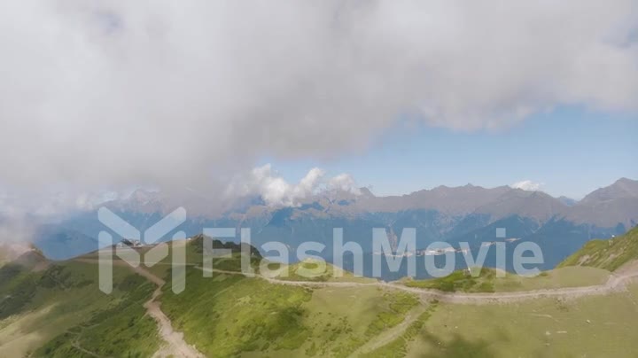 Drone video 4k footage of a mountain landscape. Big clouds over the mountains. Hill road. View from above