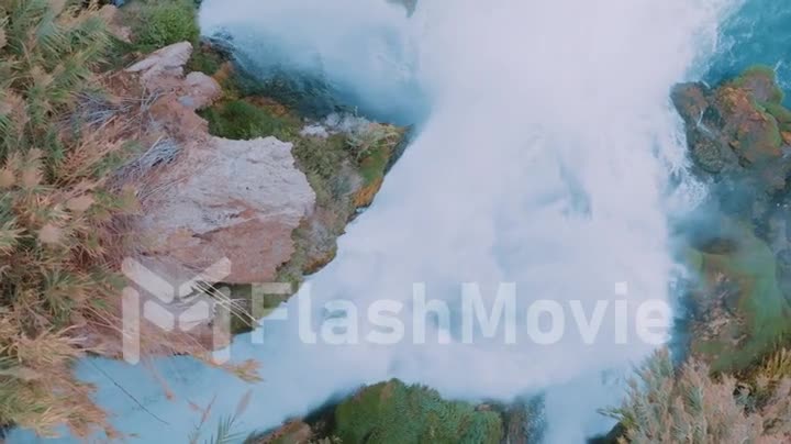 Slow motion shot of a stormy waterfall on a rock. Running water. Wonderful natural landscape. Slow motion drone footage