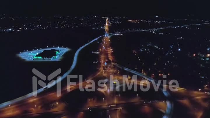 Aerial 4k view urban night traffic on the illuminated roundabout