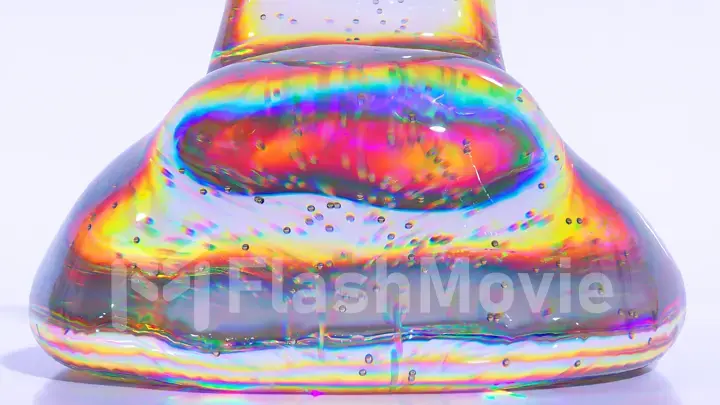 Abstract concept. Liquid gel diamond matter flows down onto a smooth glossy surface. White background. Rainbow color.